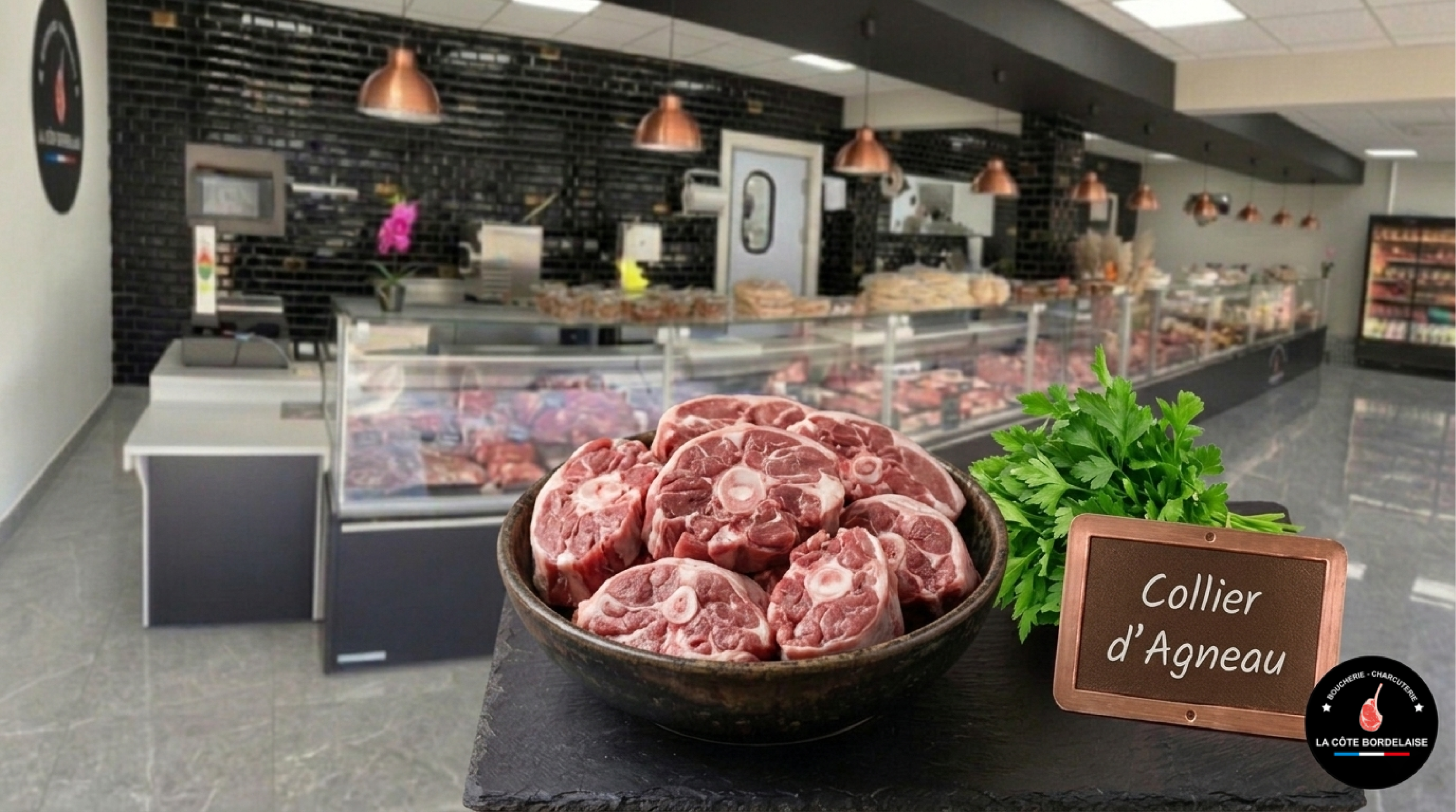 Collier d'agneau frais et charnu, disposées sur un billot de bois traditionnel dans la boucherie La Côte Bordelaise, avec quelques herbes de Provence et gousses d'ail en accompagnement.